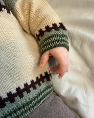 Baby iført Cross Cardigan Baby med fokus på ribkanterne