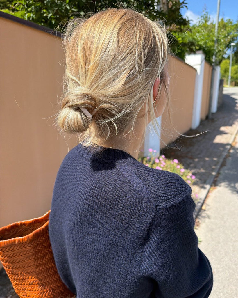 Kvinde iført blå Vega Sweater set bagfra