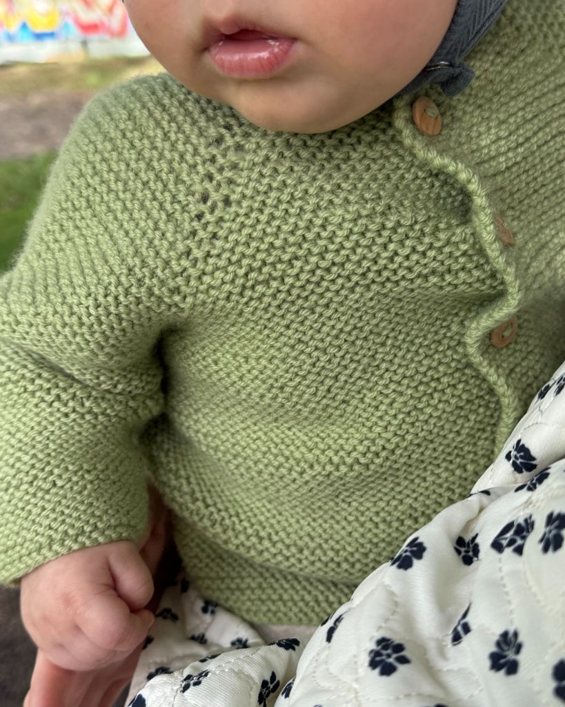 Baby iført grøn Begynderjakken