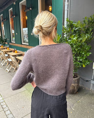 Kvinde iført mørkelilla Ivy Cardigan set bagfra