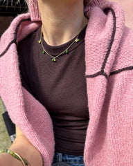 Kvinde med lyserød Linea Sweater over skuldrene