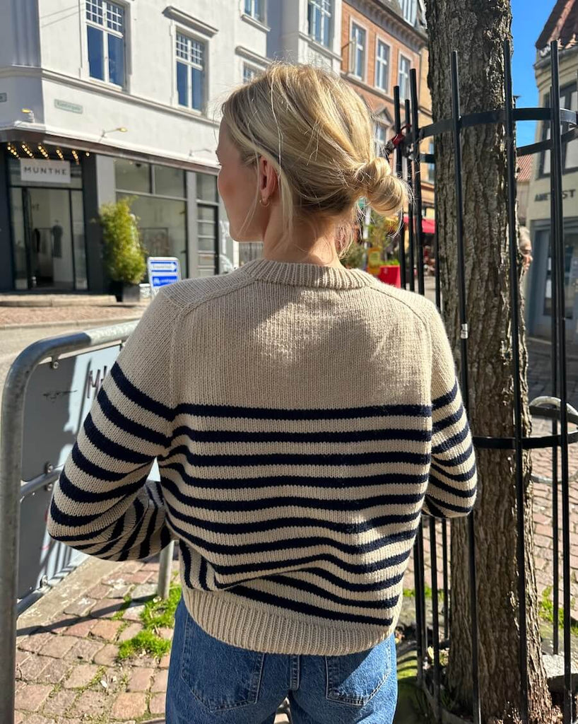 Kvinde iført hvid og blå Lyon Sweater