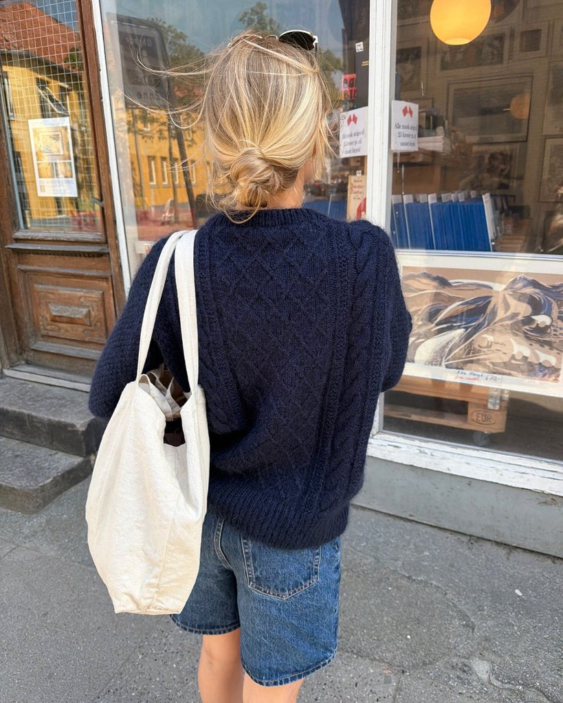 Kvinde iført blå Moby Sweater set bagfra