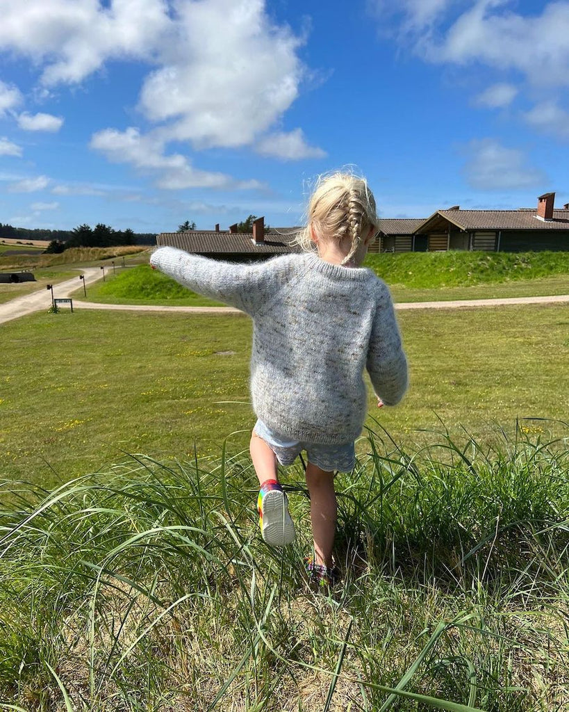 Barn iført nistret lyseblå Monday Sweater Junior 