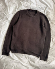 Brun Niels Sweater liggende på sengetøj