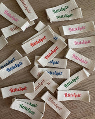 Bord fyldt af Petiteknit farvemix labels