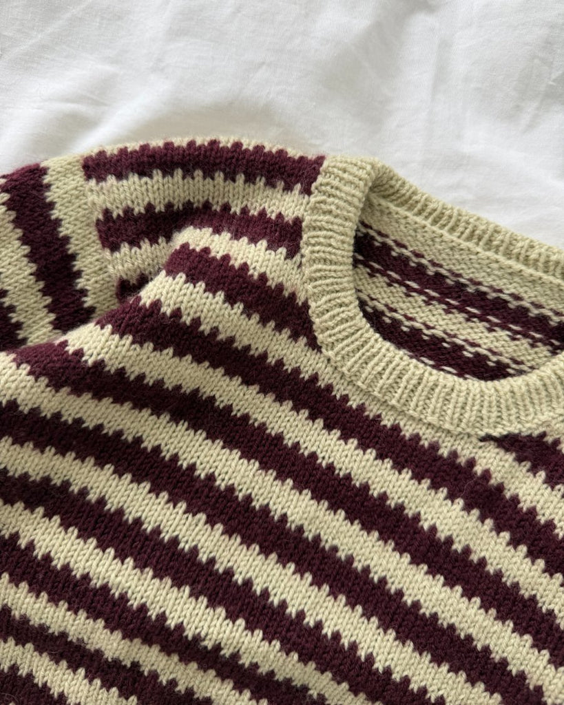 Closeup af bordeaux og grøn Otto Sweater Baby liggende