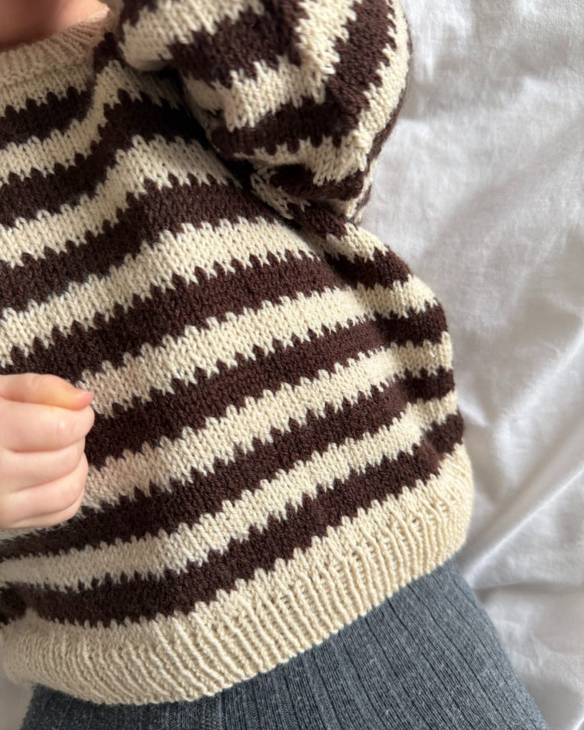Closeup af baby iført hvid og brun Otto Sweater Baby