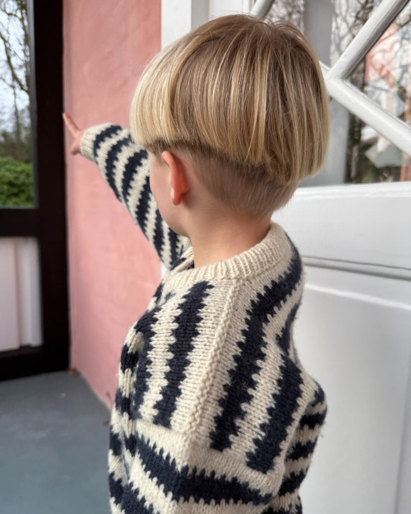 Barn iført blå og hvid Otto Sweater Junior