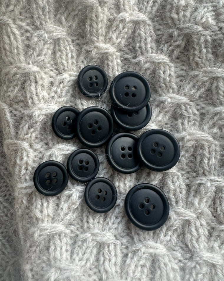 6 galalit knapper i sort på bord