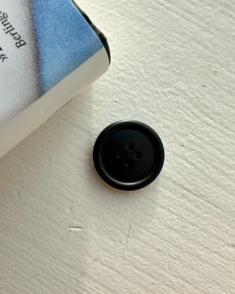 Én 23 mm sort galalit knap 