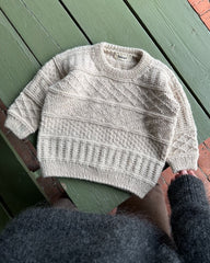Lys beige Storm Sweater Junior på grønt træbord