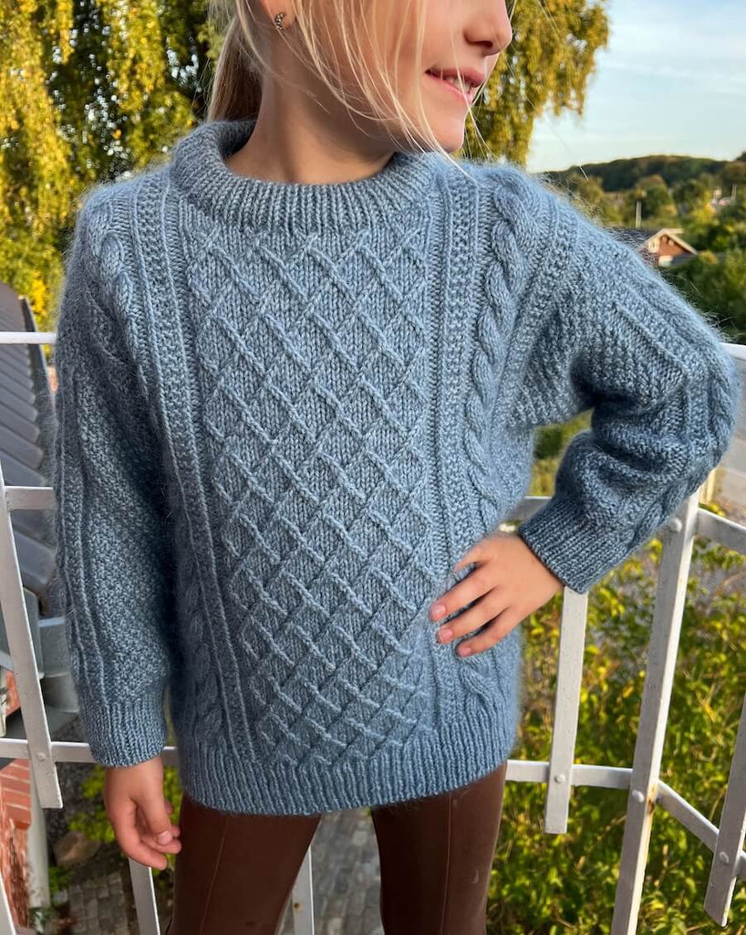 Barn iført blå Moby Sweater Junior 