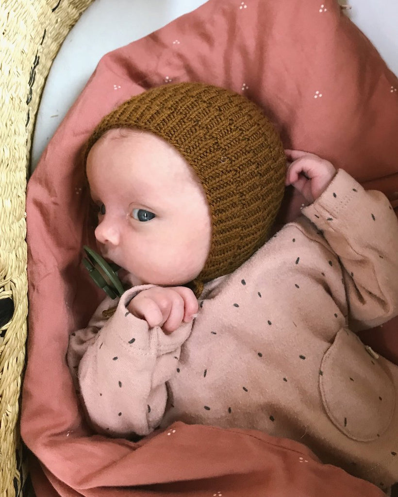 Baby iført brun Ankers Kyse 