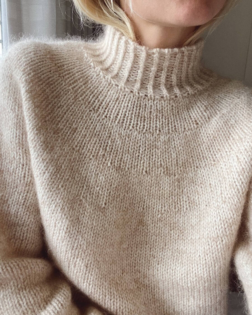 Kvinde iført hvid Novice Sweater 