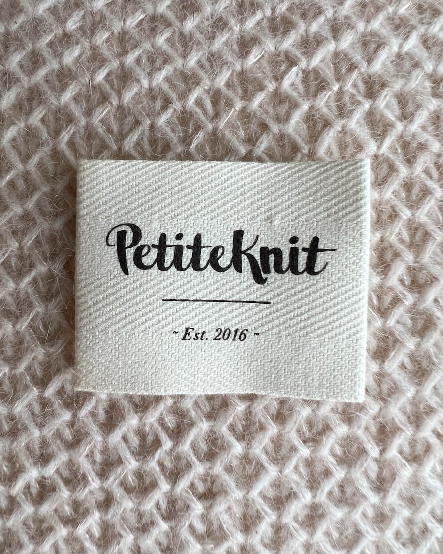 "PetiteKnit - Est. 2016" tekstillabel i økologisk bomuld 