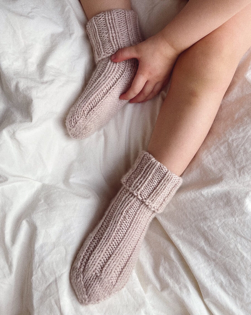 Closeup af fødder med et par lyserøde Sunday Socks Junior 