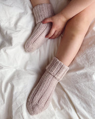 Closeup af fødder med et par lyserøde Sunday Socks Junior 