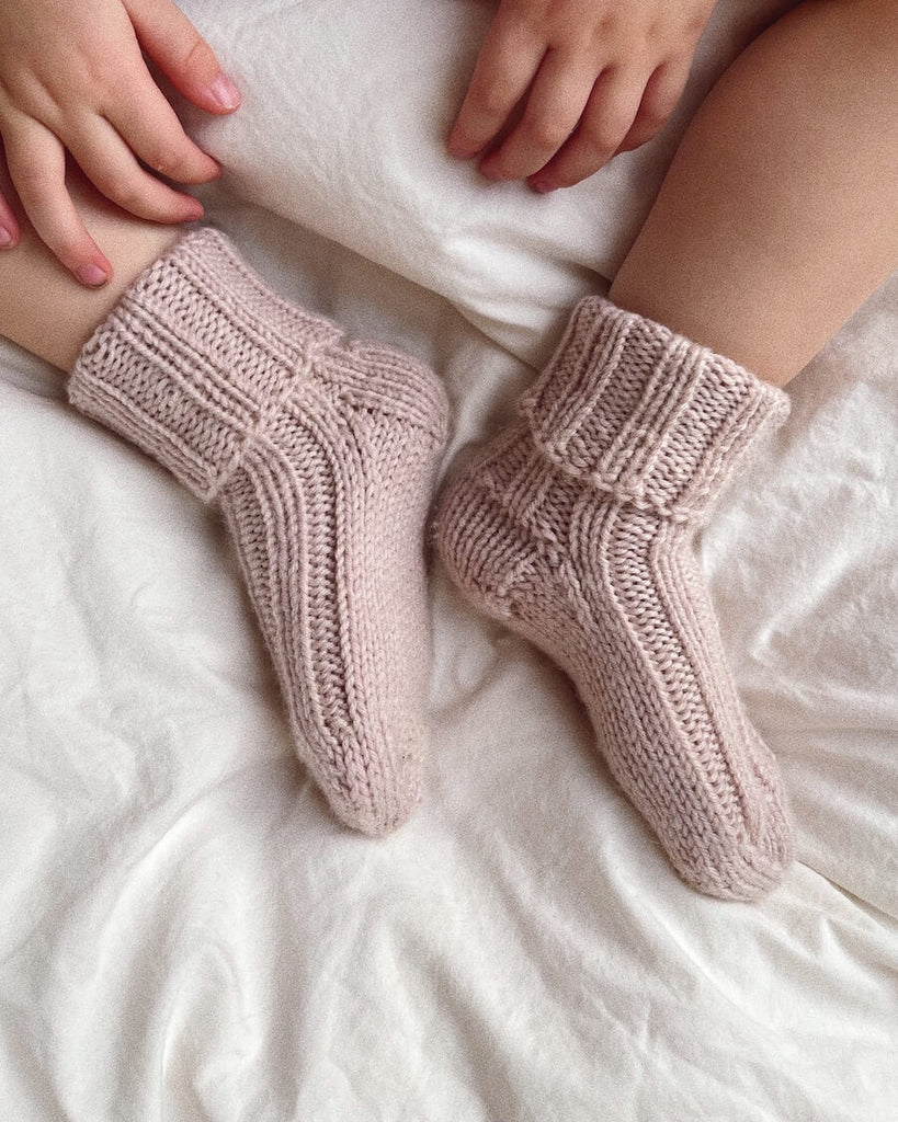 Closeup af fødder med et par lyserøde Sunday Socks Junior 