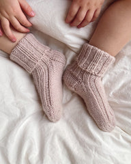Closeup af fødder med et par lyserøde Sunday Socks Junior 